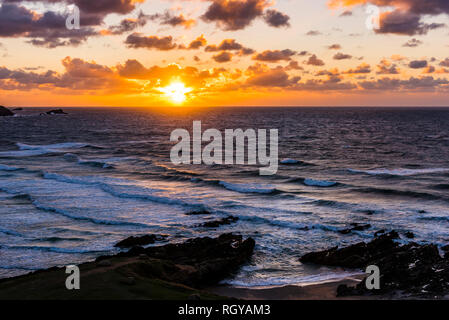 Sun setting over waves and surf at Fistral Beach, Newquay, Cornwall, UK Stock Photo