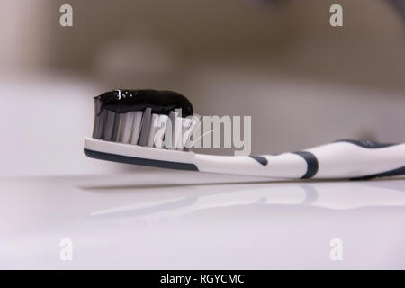 Black toothpaste on a toothbrush - closeup Stock Photo