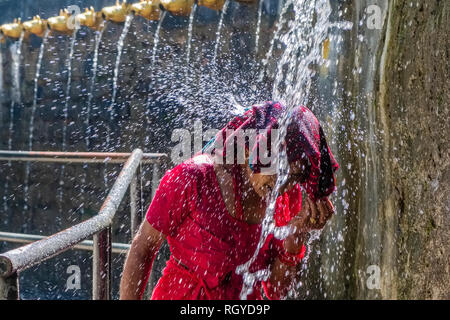 Pilgrim taking shower at the 108 wells spending ice cold holy water in Muktinath Temple Stock Photo