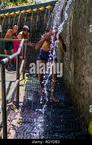 Pilgrim taking shower at the 108 wells spending ice cold holy water in Muktinath Temple Stock Photo