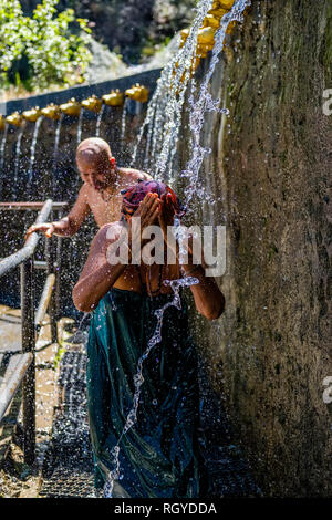 Pilgrim taking shower at the 108 wells spending ice cold holy water in Muktinath Temple Stock Photo