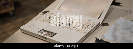 A laptop computer completely destroyed by a hammer. Stock Photo