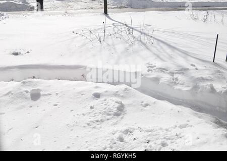 Landscape of Snow Covered Area with Shoveled Path and Shadows on a Sunny Day Stock Photo