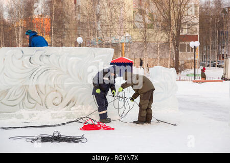 Electricians mount a power cable to illuminate ice figures. Stock Photo