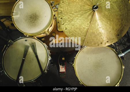 music, people, musical instruments and entertainment concept - male musician or drummer playing drum kit at studio over holidays lights background Stock Photo