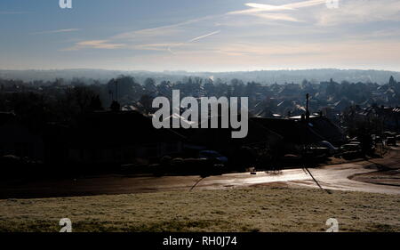 Kent, UK. 31st Jan, 2019. The early morning sun shines through a blue crisp sky illuminating the rooftops, the January cold snap hits the south east of England, looking out across the valley in Kent, steam and vapour plumes from chimneys and roofs, the icy tiled roof tops glisten in the low sunshine. 2018 --- Image by Credit: Paul Cunningham/Alamy Live News Stock Photo