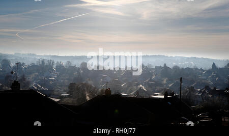 Kent, UK. 31st Jan, 2019. The early morning sun shines through a blue crisp sky illuminating the rooftops, the January cold snap hits the south east of England, looking out across the valley in Kent, steam and vapour plumes from chimneys and roofs, the icy tiled roof tops glisten in the low sunshine. 2018 --- Image by Credit: Paul Cunningham/Alamy Live News Stock Photo