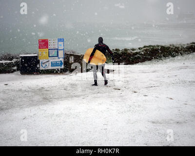 Newquay, Cornwall. 31st Jan 2019. UK Weather: Fistral Beach Surfer in the snow storm. Newquay, Cornwall, 31st January 2019. UK weather: Credit: Robert Taylor/Alamy Live News Stock Photo