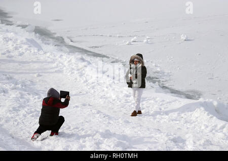 Chicago, USA. 31st Jan, 2019. A woman poses for photos by frozen Lake Michigan in Chicago, the United States, Jan. 31, 2019. Chicago, the biggest city in the U.S. Midwest, was struck by the polar vortex with the minimum temperature reaching minus 30 degrees Celsius in the city. Credit: Wang Ping/Xinhua/Alamy Live News Stock Photo