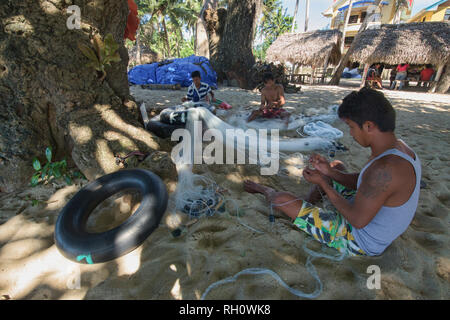 Fishermen mending their nets, Saud Beach, Pagudpud, Luzon, Philippines Stock Photo