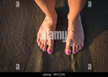 Feet washed by sea waves Stock Photo