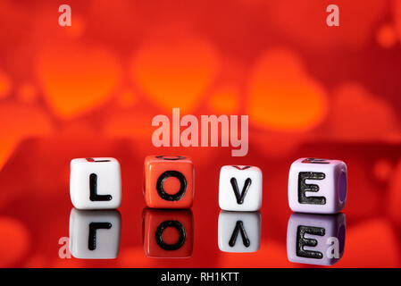 Word love  from cubes with reflection on bright blurred background. Stock Photo