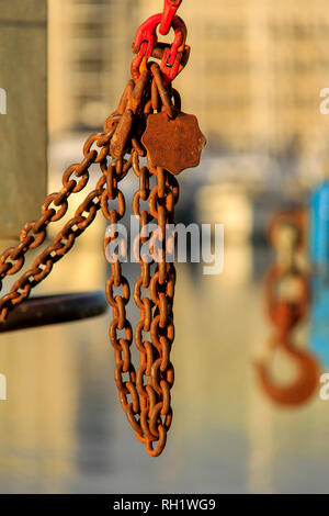 Crane shackles, hooks and rusty chain with blurry background Stock Photo