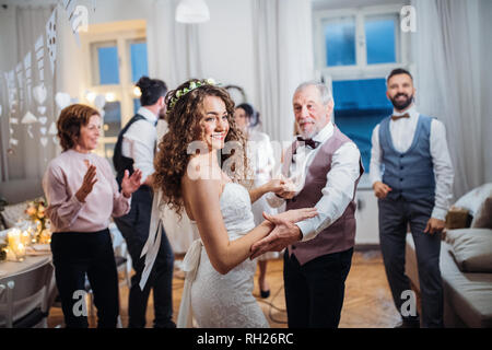 A young bride dancing with father or grandfather and other guests on a wedding reception. Stock Photo