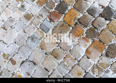 Old stone pavement covered with snow in winter Stock Photo