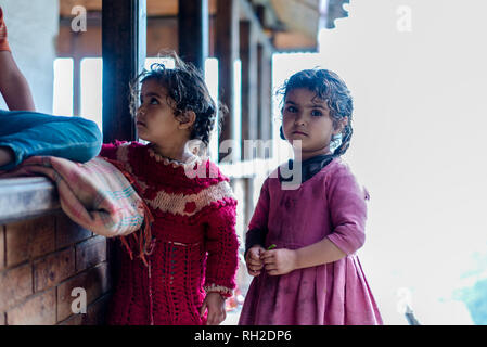 Kullu, Himachal Pradesh, India - August 09, 2018 : Photo of twins girl near her house, on the street in Himalayan village, India Stock Photo