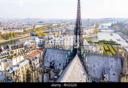 View from the tower of Notre-Dame de Paris over the ile de la Cite and the Seine with the rooftop and spire of the cathedral in the foreground. Stock Photo