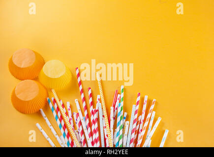 Drinking paper colorful straws for summer cocktails on yellow background with copy space. Top view. Stock Photo