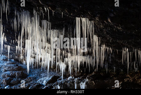 Many icicles hanging from the ceiling of the cave Stock Photo