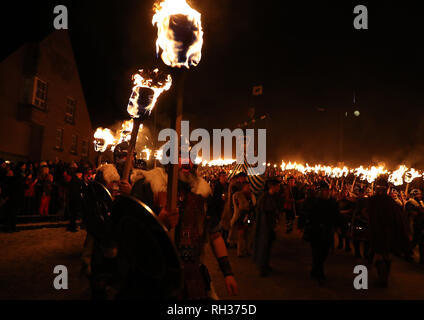 Members of the Jarl Squad march beside the Galley as they head through Lerwick ahead of the Galley being set on fire on Shetland Isles during the Up Helly Aa Viking festival. Originating in the 1880s, the festival celebrates Shetland's Norse heritage. PRESS ASSOCIATION Photo. Picture date: Tuesday January 29, 2019. Stock Photo