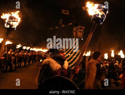 Members of the Jarl Squad march beside the Galley as they head through Lerwick ahead of the Galley being set on fire on Shetland Isles during the Up Helly Aa Viking festival. Originating in the 1880s, the festival celebrates Shetland's Norse heritage. PRESS ASSOCIATION Photo. Picture date: Tuesday January 29, 2019. Stock Photo