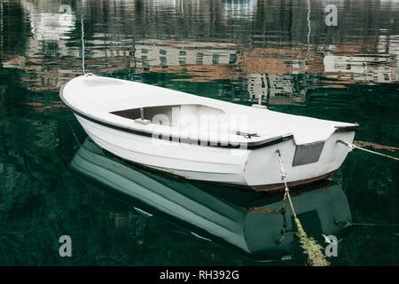 White empty fishing wooden boat in the sea near the shore. Stock Photo