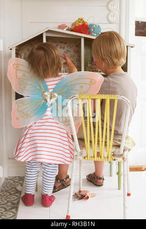 Rear view of girl playing with doll house Stock Photo - Alamy