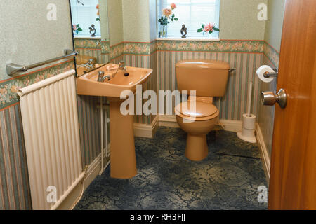 An old fashioned brown coloured suite in a downstairs toilet Stock Photo