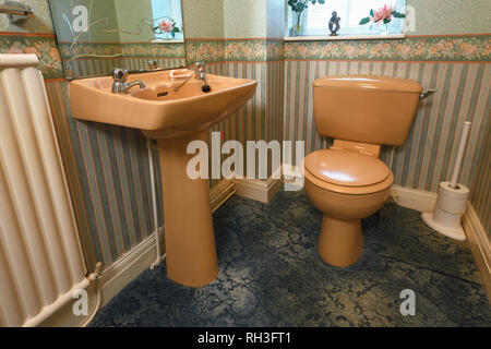 An old fashioned brown coloured suite in a downstairs toilet Stock Photo