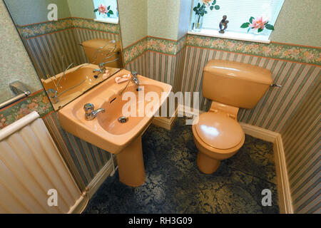 An old fashioned brown coloured suite in a downstairs toilet Stock Photo