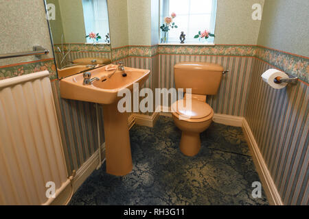 An old fashioned brown coloured suite in a downstairs toilet Stock Photo