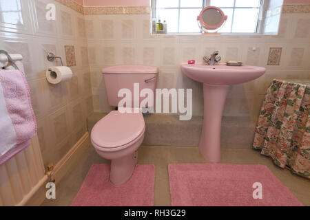 An old fashioned pale pink coloured bathroom suite Stock Photo