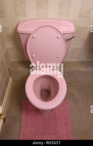 An old fashioned pale pink coloured bathroom toilet Stock Photo