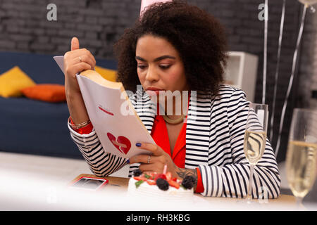 Nice pleasant woman being involved in reading Stock Photo