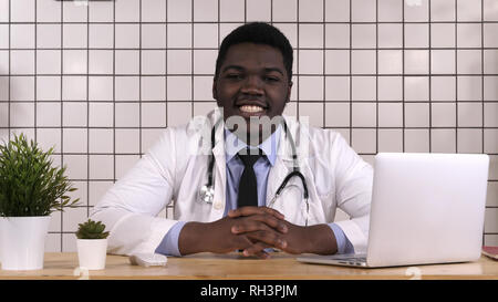 Young doctor at his working place smiling. Stock Photo