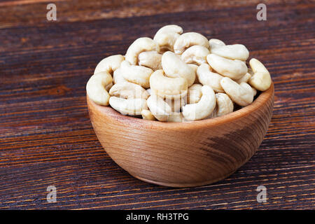 Cashew nuts in wooden bowl over wooden background(selective focus). Stock Photo