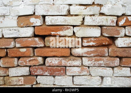 Brick wall with large gaps between bricks with shabby whitewash Stock Photo