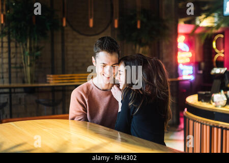 Theme love and holiday Valentines Day. couple of college students together in Caucasian heterosexual lovers winter inside the cafe sit at empty table  Stock Photo