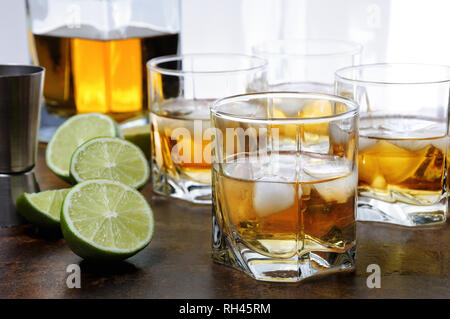 Alcohol cocktail with brandy, whiskey or rum with Ginger Ale, lime and ice in glasses