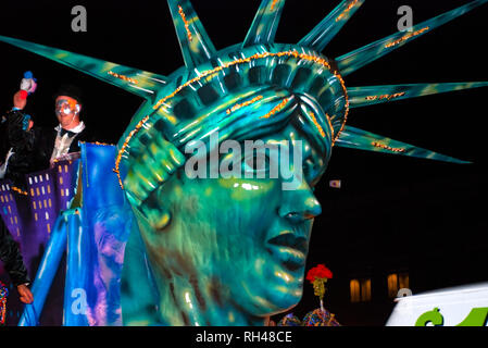 Lady Liberty towers over a float as a reveler throws a stuffed animal to the crowd during the Order of Inca Mardi Gras parade in Mobile, Alabama. Stock Photo