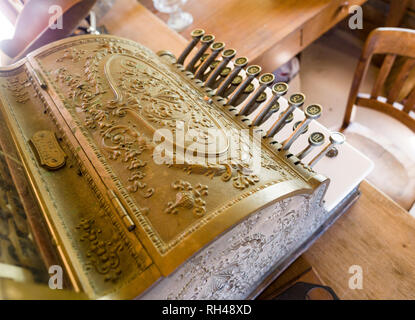 Old Manual decorated Cash register: Cast in solid metal this highly decorated cash register and it levers is part of a museum display. Stock Photo