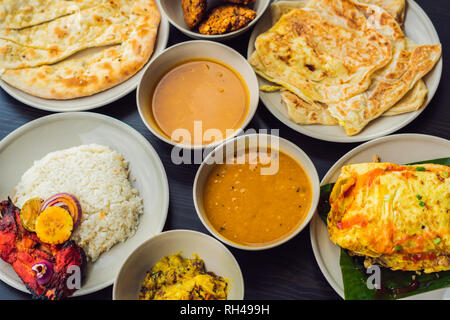 Assorted indian food on dark wooden background. Dishes and appetizers of indian cuisine. Curry, butter chicken, rice, lentils, paneer, samosa, naan Stock Photo