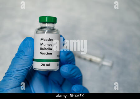 Measles, mumps and rubella combined vaccine vial with injection syringe Stock Photo