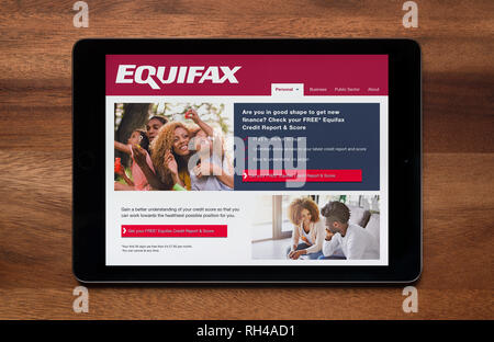 The website of Equifax is seen on an iPad tablet, which is resting on a wooden table (Editorial use only). Stock Photo