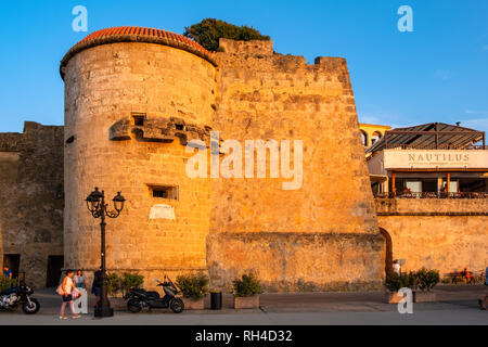 Alghero, Sardinia / Italy - 2018/08/10: Summer sunset view of the Alghero old town quarter with historic defense walls and fortifications Stock Photo