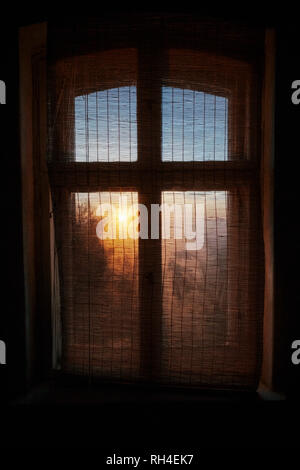 Ethereal sunrise behind gauze window curtain Stock Photo