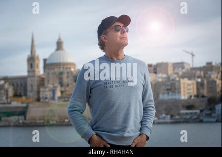 man wearing a sweatshirt with the message 'there are so many beautiful reasons to be happy' printed on it. Stock Photo