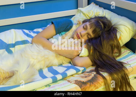 Girl sleeping in a crib with a fluffy cat Stock Photo