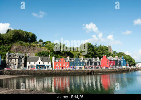 Colourful painted houses along the harbour front at Tobermory, Mull, UK with their bright reflections in the water. Stock Photo