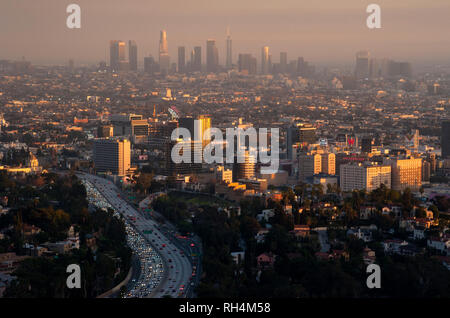 View of Hollywood with downtown Los Angeles in distance through smoggy skies at sunset. Stock Photo